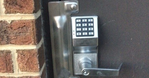 Commercial locksmith working on a high-security office door lock