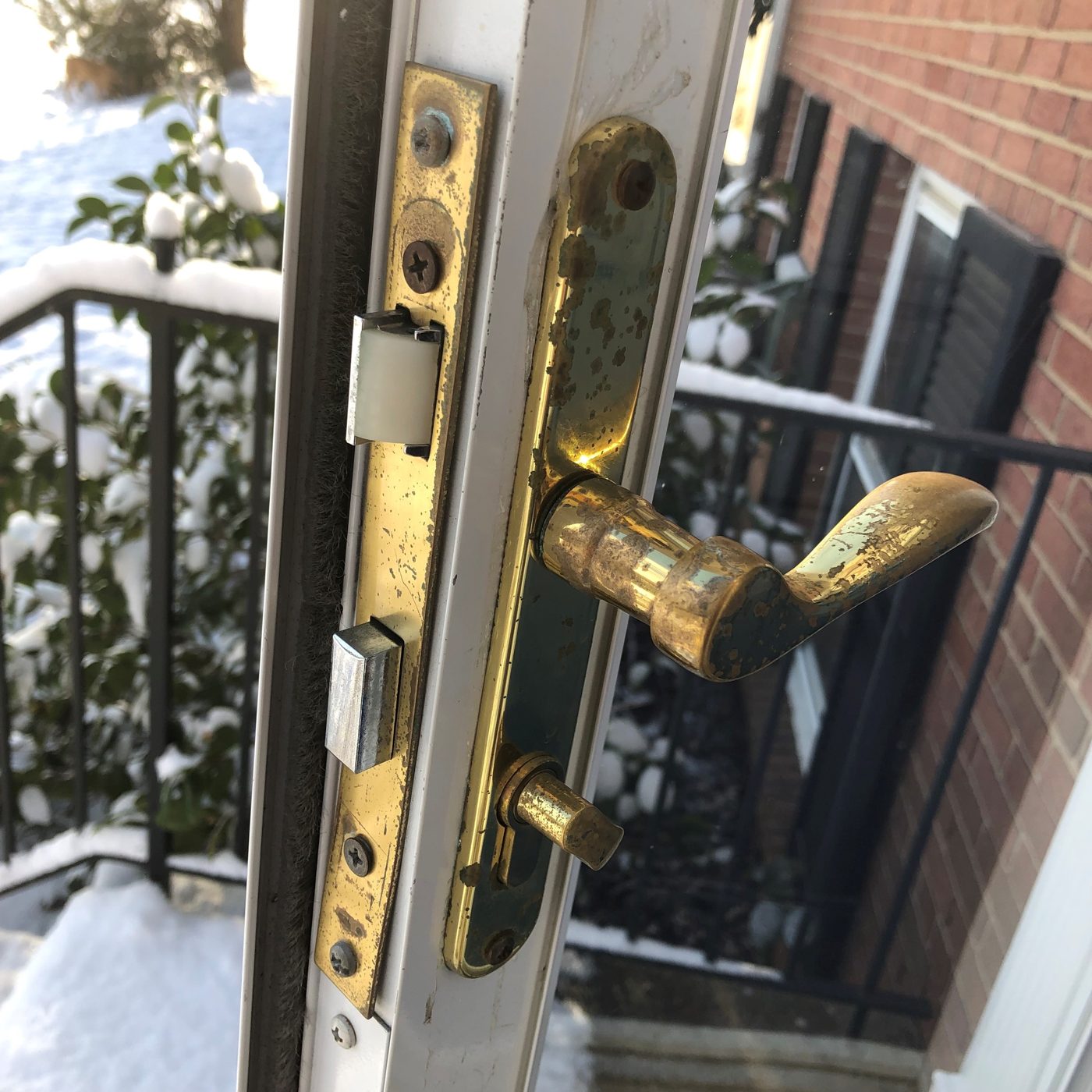 Multipoint lock hardware on the edge of an entry door, showing the latch and bolt points