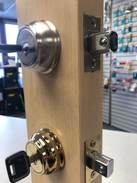 High-security deadbolt display mounted on a door section in the Area Safe showroom