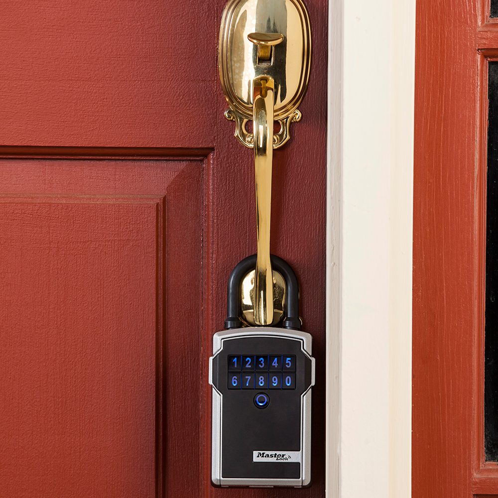 Master Lock Bluetooth smart key box hanging on a front-door handleset